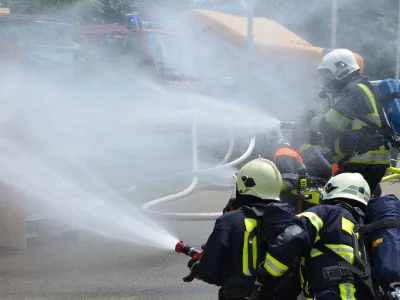 A group of firefighters spraying water over a fire