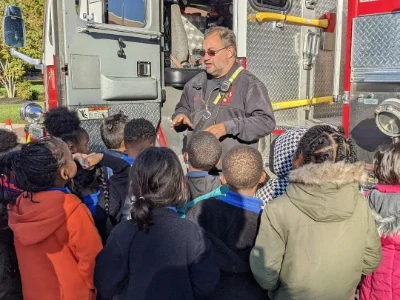 A volunteer firefighter teaching kids about the duties of firefighters