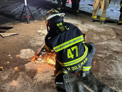 A firefighter from Station 47 putting out a fire on the ground